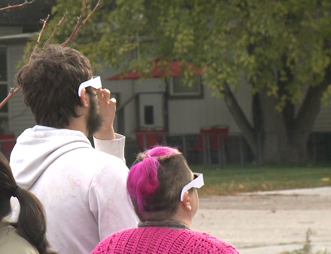 Spectators watch the eclipse before clouds cover it. 